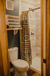 A flush toliet and elegantly tiled shower